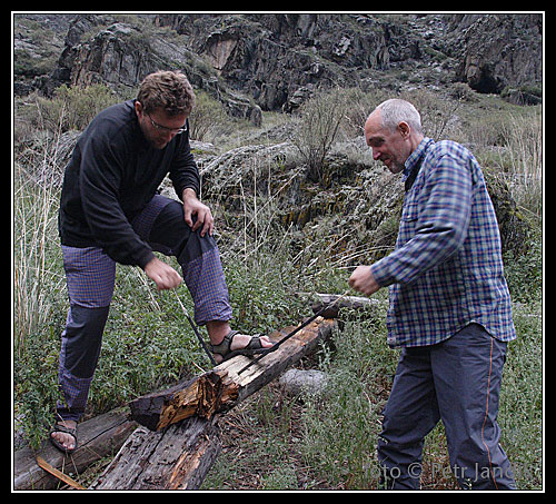 Petr a první Tomáš se zahřívají řezáním zbytků srubu